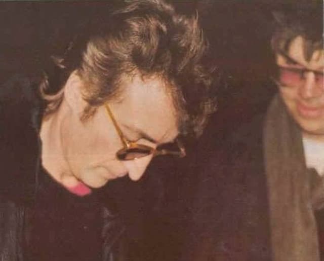 Ultima fotografia scattata a John Lennon. Il cantante stava facendo un autografo al suo assassino che si può vedere affianco a lui.