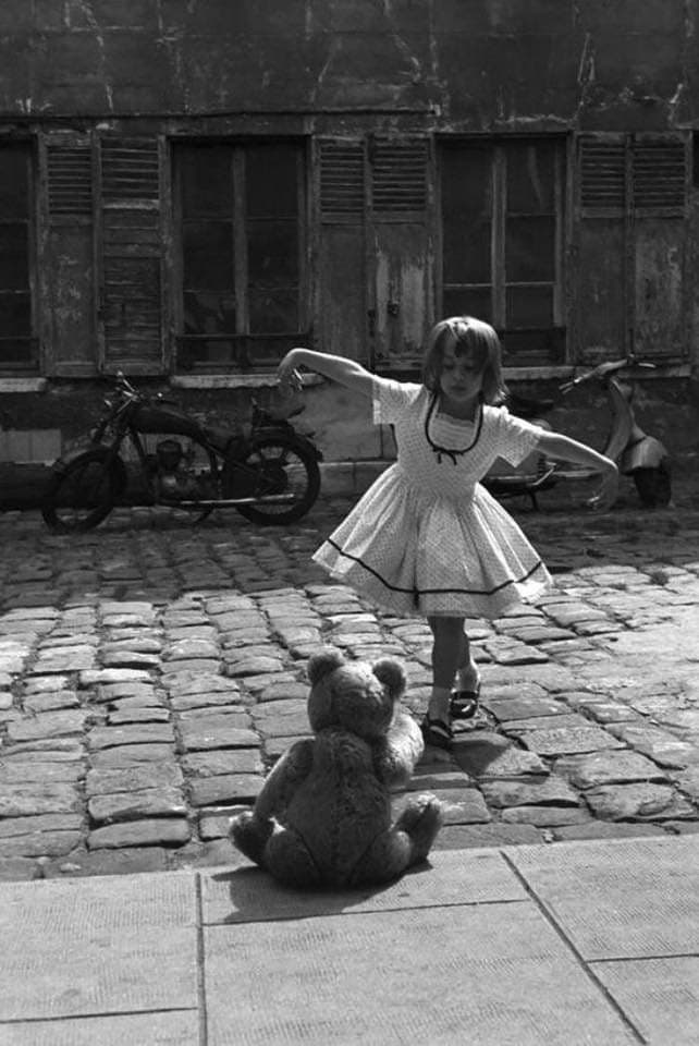 Una bambina balla per il suo orsacchiotto per le strade di Parigi nel 1961