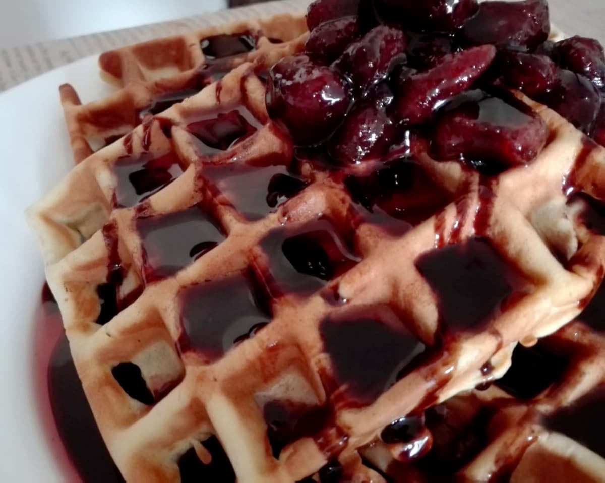 Waffle alla vaniglia, con fragole sciroppate.